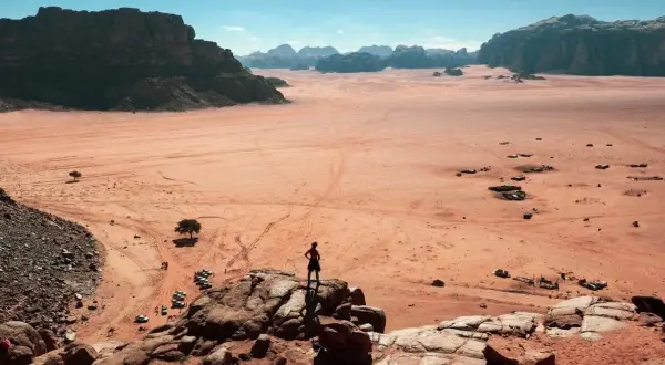 Pustynia Wadi Rum w Jordanii, gdzie turysta podziwia krajobraz. Wiza do Jordanii otwiera drogę do takich widoków.