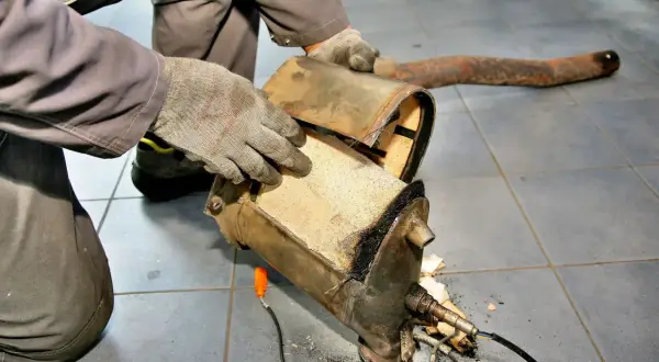 Mechanik ogląda przepalony DPF, zastanawiając się, ile się wypala dpf.