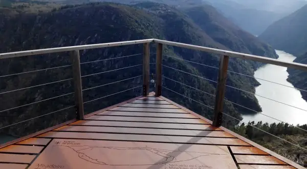 Mirador de Santiorxo con vistas a un río serpenteante entre montañas boscosas y picos nevados.