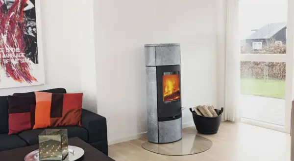 Un poêle à bois moderne, idéal pour installer un poêle à bois dans une maison sans conduit, chauffe agréablement le salon.