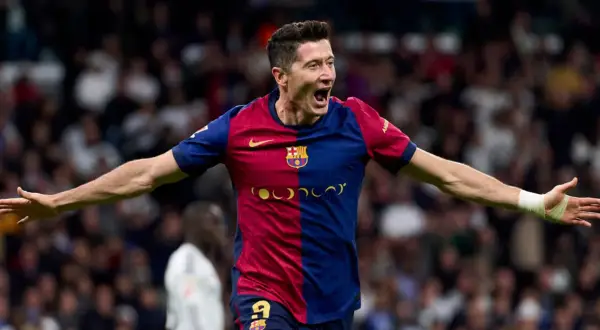 Robert Lewandowski w barwach Barcelony, z otwartymi ramionami, świętuje bramkę. Więcej informacji o jego karierze znajdziesz tutaj.