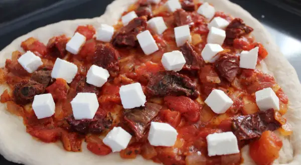 Serce z ciasta z sosem pomidorowym, suszonymi pomidorami i kostkami sera feta.