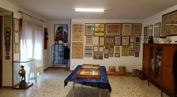 Interno del museo di Napoli, collezione Bonelli, con locandine teatrali d'epoca alle pareti e vetrine espositive.