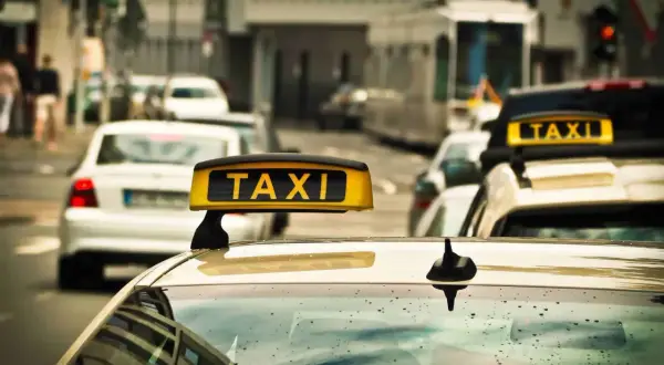 Gelbes Taxi-Schild auf einem Auto in einer Stadt. Ein Taxi in Polen wartet auf Fahrgäste.
