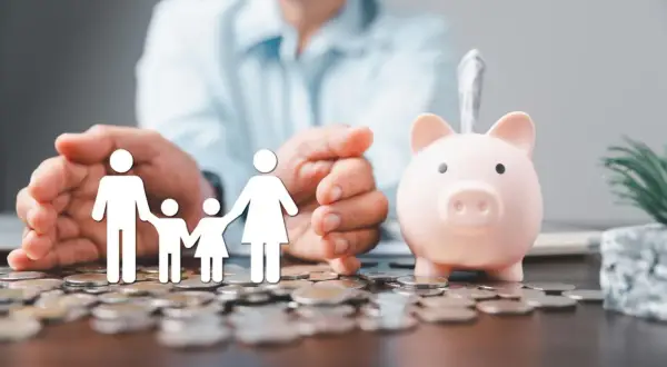 Rodzina na stosie monet, obok świnka-skarbonka. Czy pożyczka może być w gotówce? Finansowe wsparcie dla bliskich.