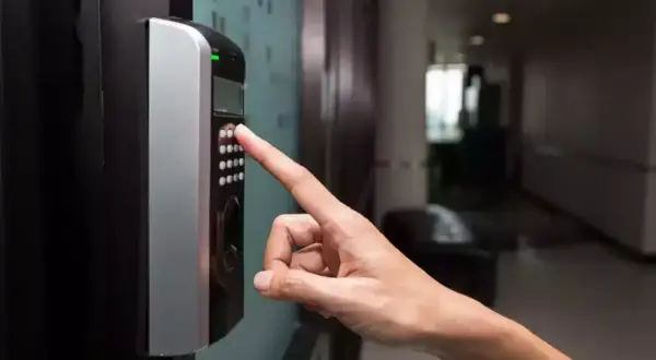 Doigt appuyant sur un clavier d'accès, le voyant vert allumé. Une fausse alerte ?