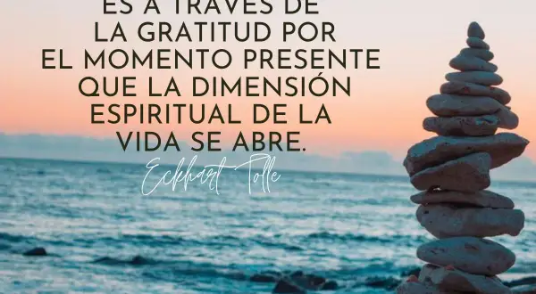 Torre de piedras en la playa al atardecer, con la frase "Es a través de la gratitud por el momento presente que la dimensión espiritual de la vida se abre." Eckhart Tolle. Frases profundas.