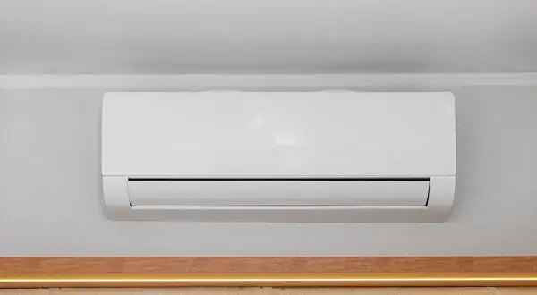 Unità interna di condizionatore bianco montata a parete, con canalina nascosta per un'installazione pulita.