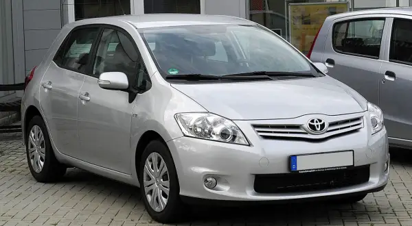 Srebrny Toyota Auris 1.6 benzyna zaparkowany na kostce brukowej.