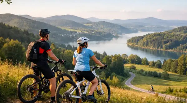 Para rowerzystów podziwia malowniczy krajobraz z jeziorem i wzgórzami. Idealne miejsce na odkrywanie tras rowerowych Podkarpacia.