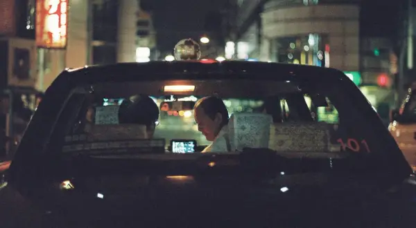 Taxi driver illuminated by a phone screen, a perfect shot for the best 35mm film for low light.
