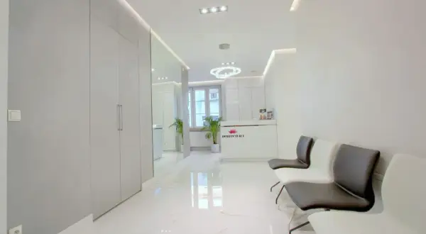 Nowoczesne wnętrze poczekalni kliniki dermatologii estetycznej z recepcją i wygodnymi fotelami.