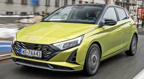 Żółty Hyundai i20 w ruchu miejskim. Sprawdź aktualną hyundai i20 cena i wybierz swój wymarzony samochód.