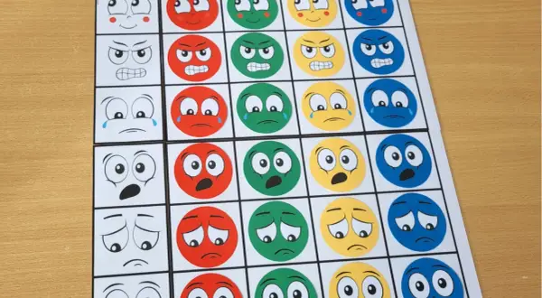 Plansza z emotikonami do nauki kodowania dla dzieci. Różne emocje na kartach, od radości po złość.
