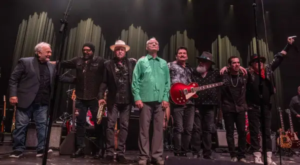 Zespół muzyczny na scenie, w tym Bill Murray w zielonej koszuli, gotowy na koncerty.