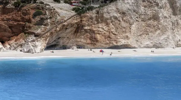 Piękna plaża Porto Katsiki z turkusową wodą i stromymi klifami. Schody prowadzą do jaskini.