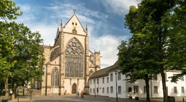 Ein Paar radelt am Münster vorbei, einem der beeindruckendsten bergisch gladbach sehenswürdigkeiten.
