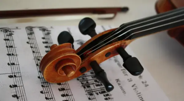 Nuty na skrzypce dla początkujących leżą obok instrumentu.