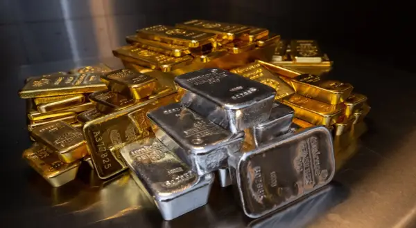 Montón de lingotes de oro y plata. El precio del oro usado hoy fluctúa con estas barras brillantes.