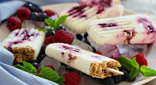 Eis selber machen mit Kindern ohne Eismaschine: Cremige Eis am Stiel mit Beeren und Müsli, garniert mit frischer Minze.