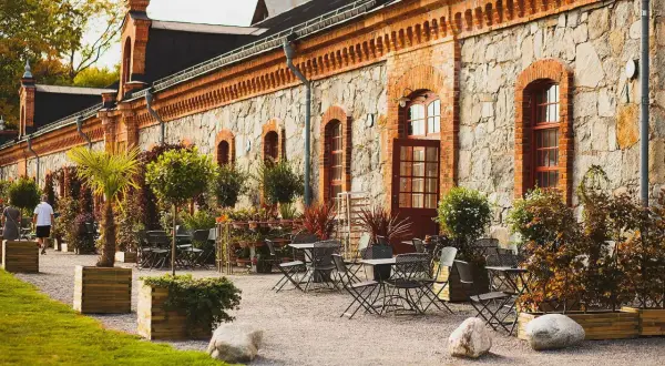 Stenbyggnad med uteplats och bord, perfekt för utomhusaktiviteter i Stockholm.