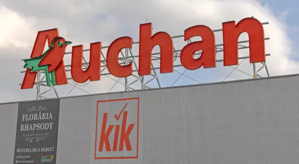 Duże czerwone logo Auchan z ptaszkiem, poniżej banery sklepów Floraria Rhapsody i Kik. Aplikacja Auchan ułatwia zakupy.