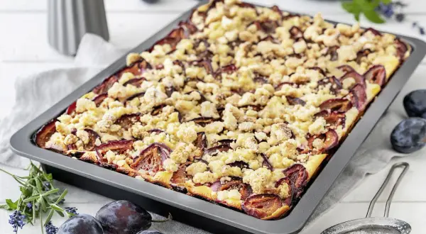Omas pflaumenkuchen vom blech mit streusel, saftig und goldbraun gebacken, mit frischen Pflaumen und knusprigen Streuseln.