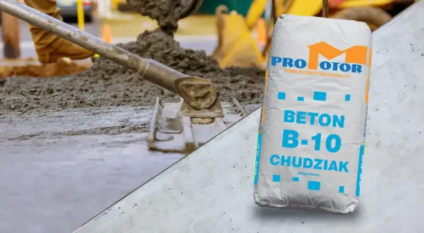 Wylewanie i wyrównywanie betonu na podbudowie, obok worek z betonem B-10 Chudziak.
