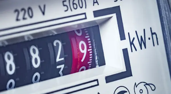 Zbliżenie na licznik energii elektrycznej. Cyfry wskazują zużycie, a obok widnieje napis "kW·h". Szukając informacji o kompensator mocy biernej cena, warto zwrócić uwagę na takie detale.