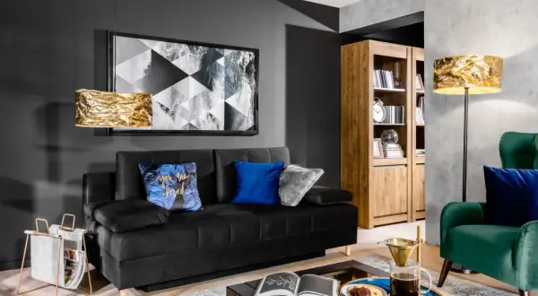 Nowoczesny salon w stylu holenderskim: czarna sofa, złote lampy, drewniana biblioteczka i zielony fotel.