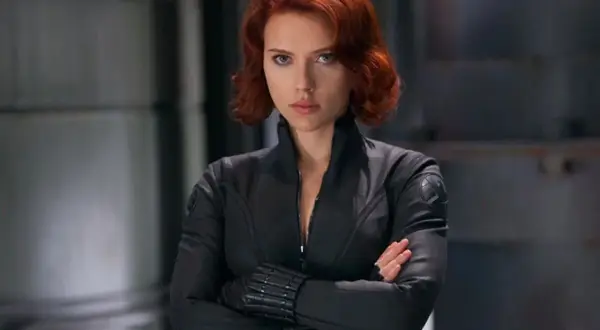 Czarna Wdowa Marvel, w czarnym kombinezonie, z rudymi włosami, pewnie patrzy przed siebie.