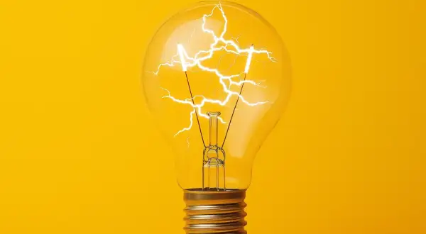 Żarówka z błyskawicami w środku, symbolizująca energię i pomysł. Jak obliczyć moc? To pytanie, na które odpowiedź może rozjaśnić umysł.