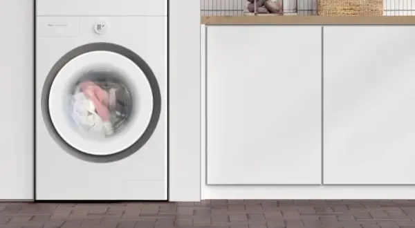 Lavatrice TCL in funzione, con panni colorati in movimento nel cestello. Il display indica 00:59, suggerendo quanto dura una lavatrice.