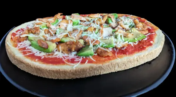 Bruschetta poulet : une tranche de pain garnie de sauce tomate, poulet grillé, avocat et fromage râpé.