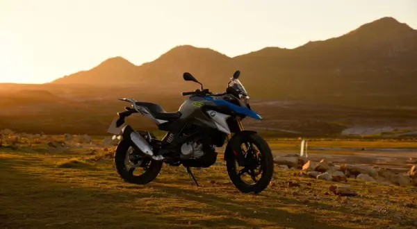 Motocykl BMW GS 310 na tle gór o zachodzie słońca.