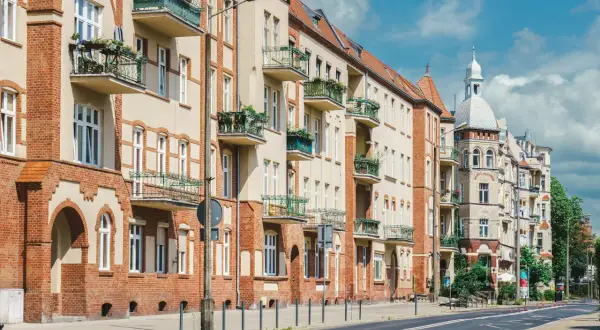 Kamienice z balkonami i zielenią. Czy teren wspólnoty mieszkaniowej jest terenem prywatnym? Pytanie to nasuwa się, patrząc na zadbane fasady i chodnik.
