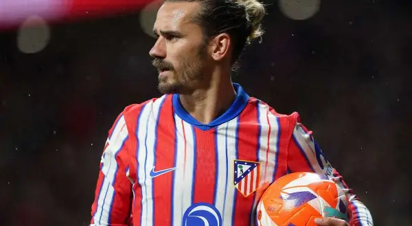 Antoine Griezmann w koszulce Atletico Madryt trzyma piłkę.