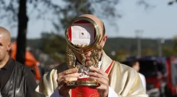 Kapłan trzyma monstrancję z hostią, przypominającą cud eucharystyczny w Sokółce.
