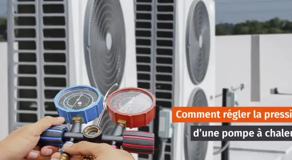 Main d'un technicien ajustant la pression eau pompe à chaleur avec un manomètre.