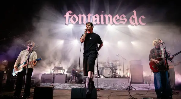 Fontaines D.C. live in Stuttgart, mit Sänger im Scheinwerferlicht und Band auf der Bühne.
