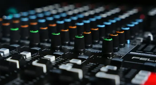 Close-up of a mixing board with colorful knobs, ready to shape sounds like a bitcrusher in FL Studio.