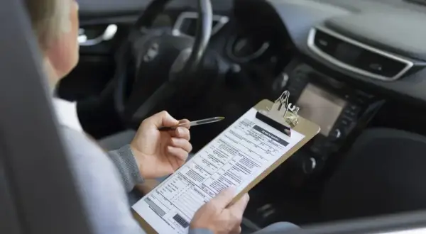 Osoba w samochodzie wypełnia dokumenty dotyczące akcyzy za auto.