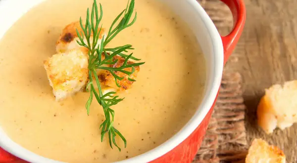 Soupe crémeuse de patidou, garnie de croûtons dorés et d'aneth frais. Une recette réconfortante pour l'automne.
