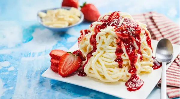 Spaghetti-Eis selber machen mit Kartoffelpresse: Cremiges Vanilleeis mit Erdbeersoße und frischen Erdbeeren. Ein süßer Genuss!