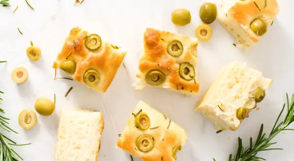 Odkryj oryginalna włoska focaccia przepis! Puszyste kromki z oliwkami i rozmarynem, idealne na przekąskę.