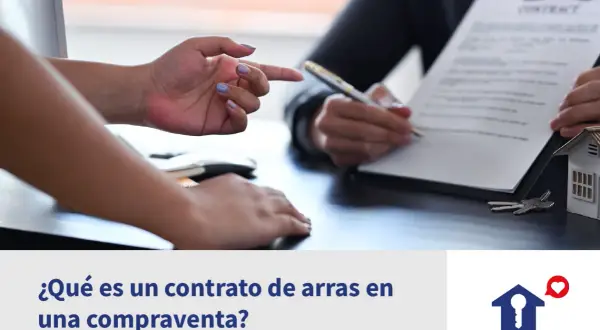 Manos firmando un contrato de arras confirmatorias, con llaves y maqueta de casa.