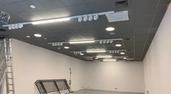 Nowoczesny sufit Armstrong z oświetleniem szynowym i klimatyzacją, gotowy do montażu.