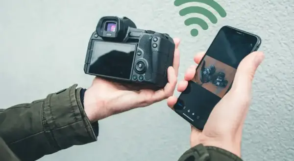 Bezprzewodowe przesyłanie zdjęć z aparatu do telefonu za pomocą SnapBridge po polsku. Widok z tyłu aparatu i ekran telefonu z podglądem.