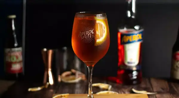 Orzeźwiający Aperol Spritz, idealny na letnie popołudnie. Wino ze spritem, podane z plasterkiem pomarańczy.