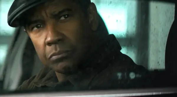Denzel Washington w czapce siedzi w samochodzie, jego spojrzenie jest intensywne, jakby działał bez litości 4.